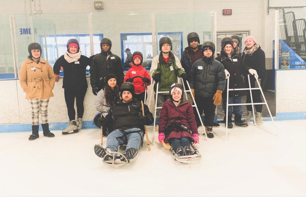 A group of participants and volunteers enjoying their adaptive skate session.
