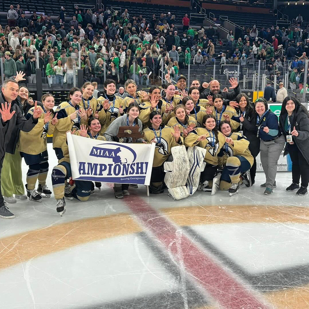 Female hockey team and coaches celebrating championship on ice