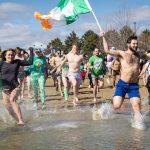 Group of people running into water for Shamrock Splash event