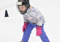 Child Learning to Skate in Hockey Helmet and Hockey Skates